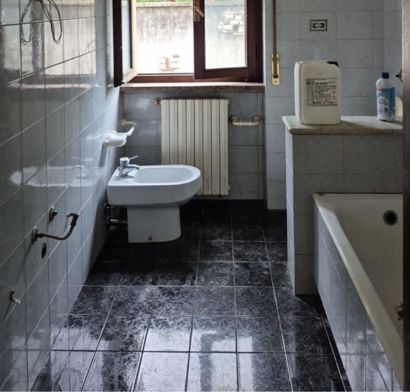 Dopo la pulizia di fino: bagno con pavimento lucido, lavabo e vasca
