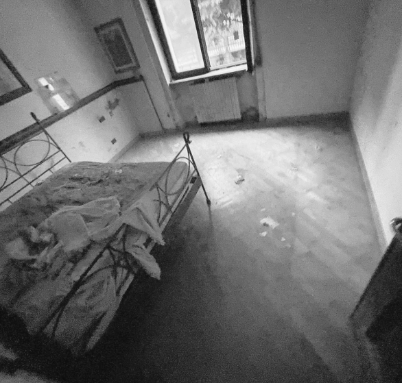 Prima dello sgombero: camera da letto con rifiuti sul pavimento