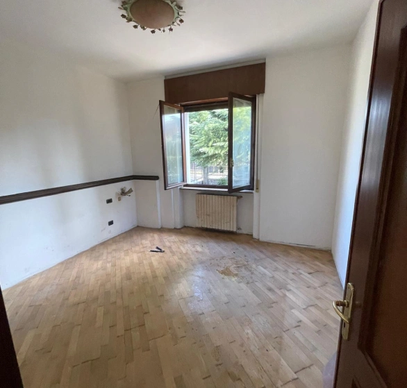 Dopo sgombero e pulizia: camera vuota con pavimento in parquet