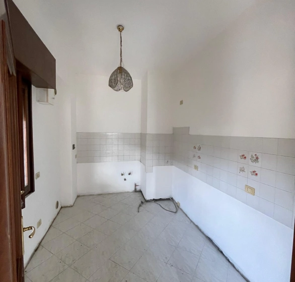 Dopo sgombero e sanificazione: cucina vuota e pulita con piastrelle a parete