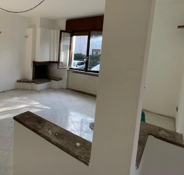 Dopo sgombero e sanificazione: soggiorno vuoto con pavimento in piastrelle