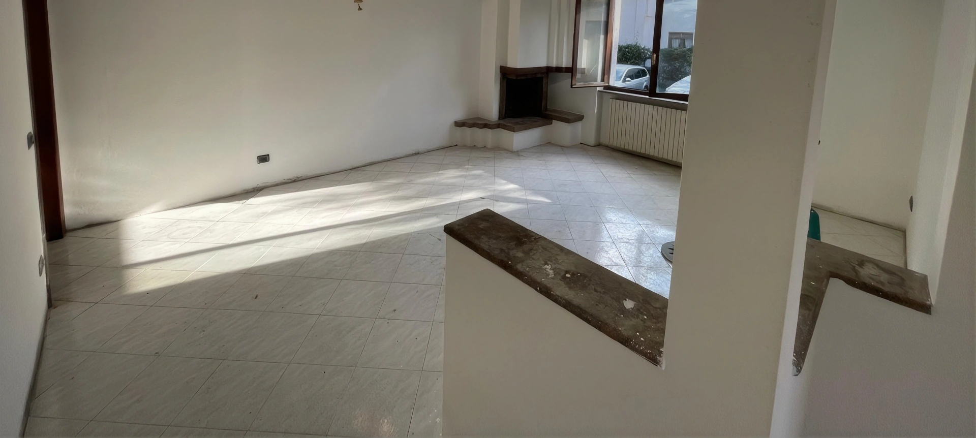 Sgombero e sanificazione per il Comune di Prevalle: soggiorno vuoto con pavimento in piastrelle a fine intervento
