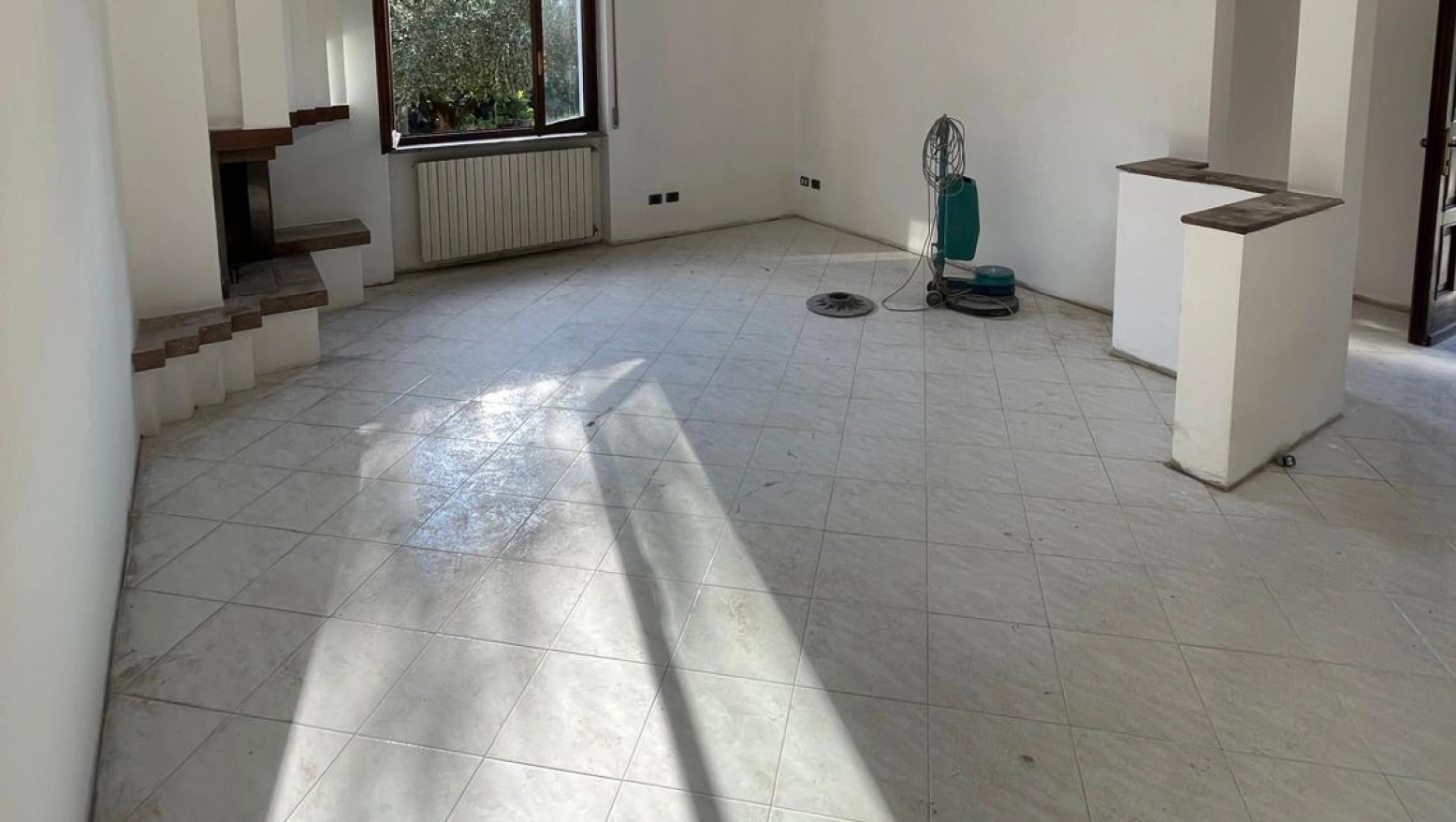 Pulizia di fino dopo sgombero e sanificazione: trattamento del pavimento con monospazzola nel soggiorno
